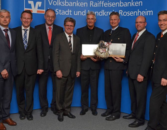 Foto von der Preisverleihung des Energiezukunftspreises 2015. Zu sehen sind 8 Männer. Zwei davon halten einen Preis in der Hand aus Metall und Holz.