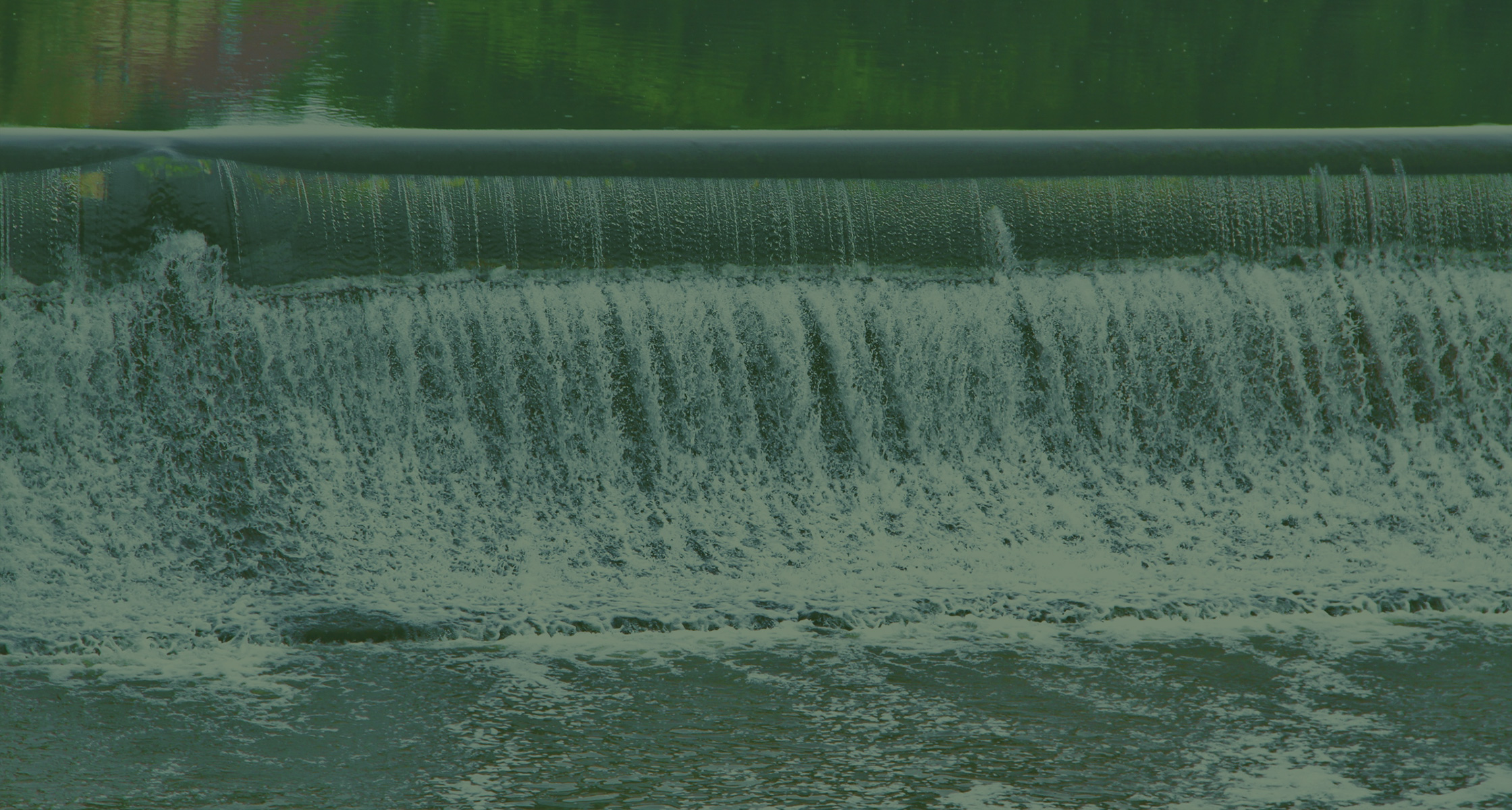 Rein dekoratives Element. Zu sehen ist eine sich bewegende Wassermasse, welche an einem Staudamm nach unten prescht. Das Bild hat insgesamt ein grünes Overlay aus gestalterischen Zwecken.